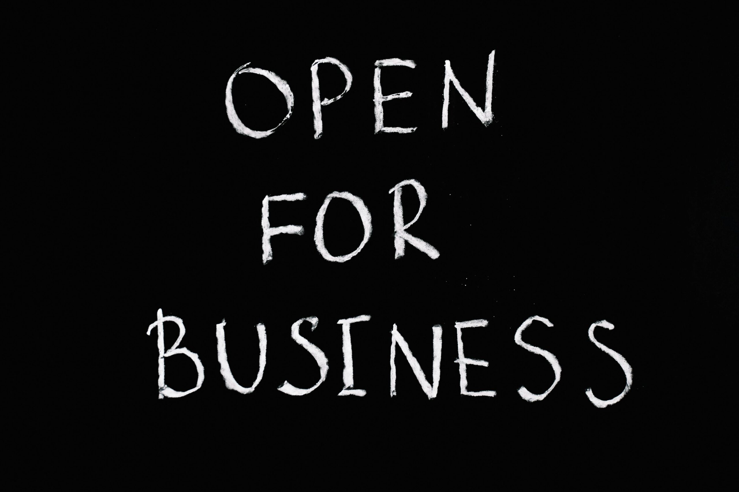 Chalkboard with 'Open for Business' text in white chalk on black background.